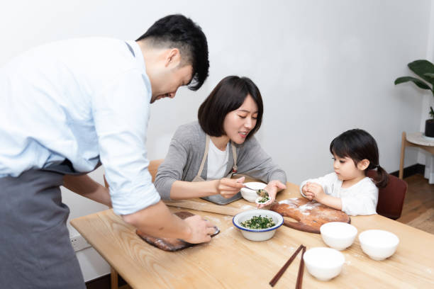 istock Young Asian mom and dad making dumplings with daughter 1248875395