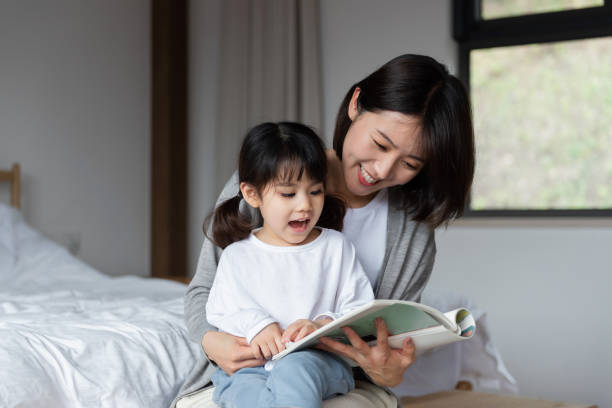 istock Young Asian mother is reading a book with her daughter 1248875477