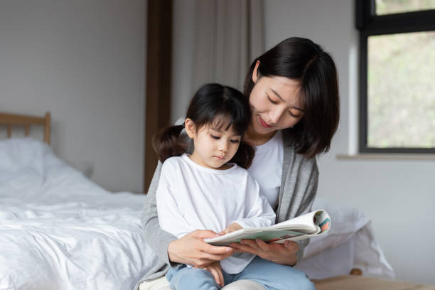 istock Young Asian mother is reading a book with her daughter 1248875567