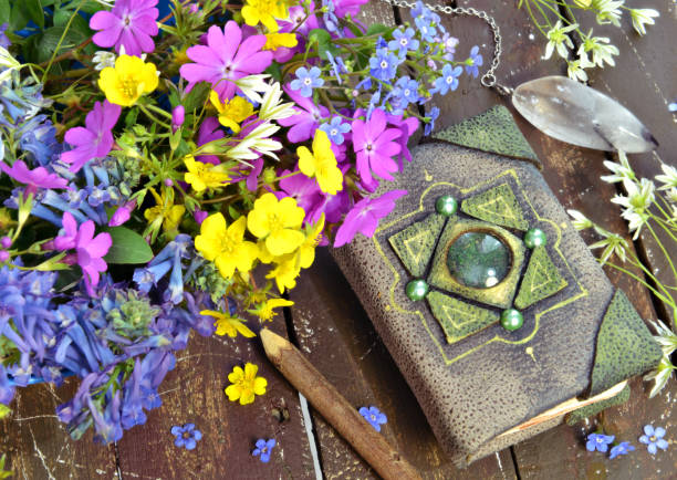 istock Still life with hand crafted diary, wildflowers, crystal decoration on green witch table. 1248875642