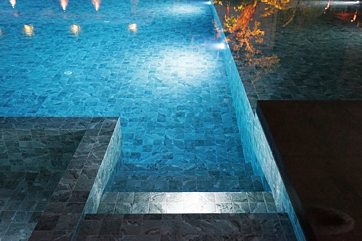 Beautiful view of the illuminated summer outdoor pool. Night time.