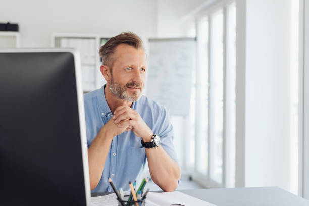 istock Thoughtful businessman staring through a window 1248878884