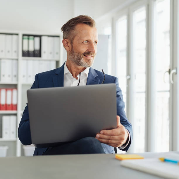 istock Inspired businessman looking out of a window 1248879020