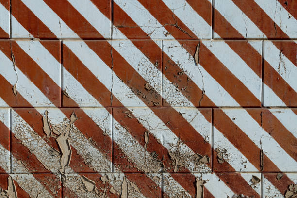 istock Old grungy concrete wall with peeling paint Red and white stripes 1248881275