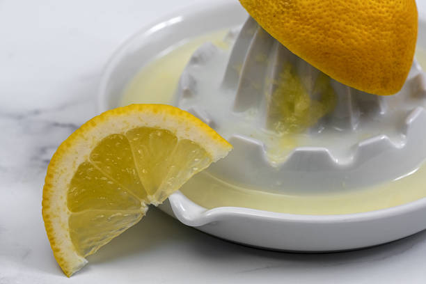 citrus press with squeezed juice and lemon stock photo