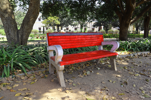 Indore, Madhya Pradesh, India, February 11, 2020 : Empty bench under tree shadow in the Lal Bagh Palace garden, Indore, Madhya Pradesh, India.