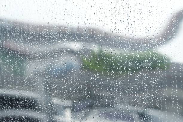 Blurred many droplets on grid net wall surface in rainy day