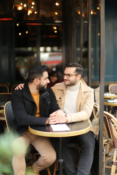 istock Two cacuasian gays talking at cafe and holding hands 1248886585
