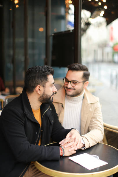 istock Two european handsome gays talking at cafe and holding hands 1248886600