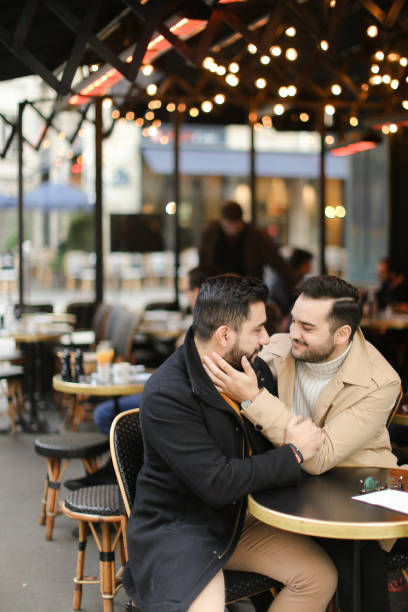 istock Caucasian happy gays sitting at cafe and hugging 1248886638