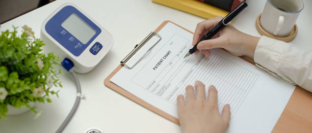 istock Doctor writing on patient chart while sitting at worktable in examination room 1248886684