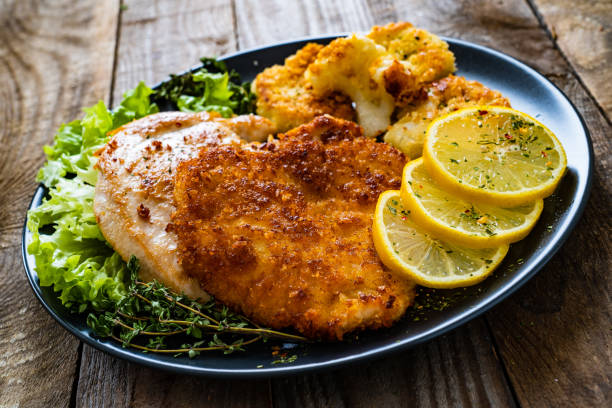 istock Fried pork chops and cauliflower on wooden table 1248892876