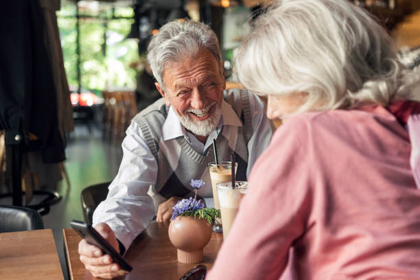 istock Loved couple drinking coffee on straw looking at smart phone 1248896910