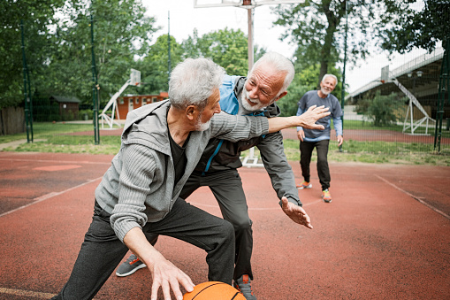 Active senior friends on basketball court