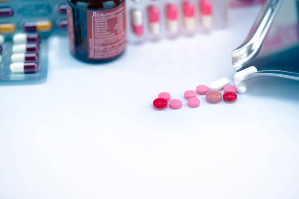 Red, pink, and white tablets pills with drug tray on blurred glass drug bottle and blister pack. Cracked tablets pills. Expired drugs. Painkiller medicine. Pharmacy shop. Pharmaceutical industry. píldoras de comprimidos rojas, rosas y blancas con bandeja de medicamentos en botella de medicamento de vidrio borroso y blíster. píldoras de comprimidos agrietados. drogas caducadas. medicina para analgésicos. tienda de farmacias. industria farmacéut