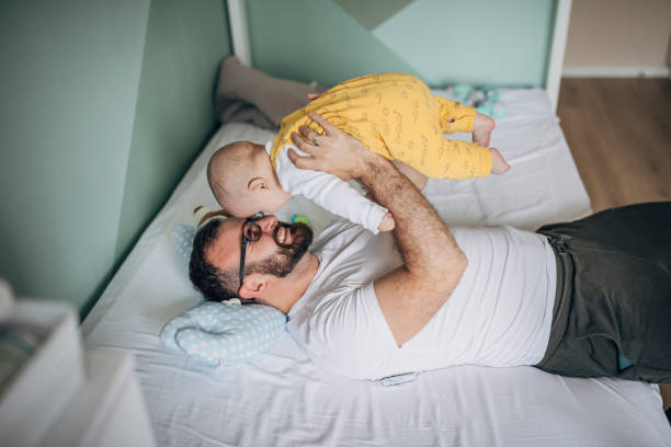 istock Father playing with his baby son on bed 1248899826