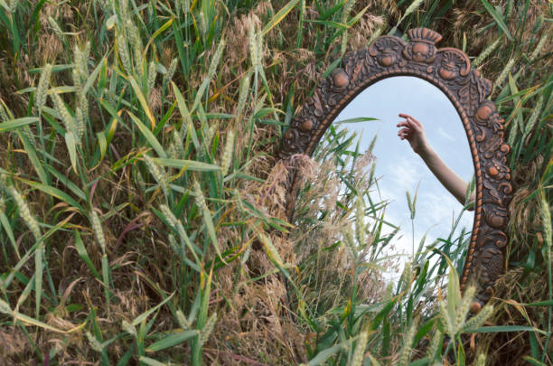 abstract image.reflection of woman hand in the old mirror in the field - mirror reflection mystery frame imagens e fotografias de stock