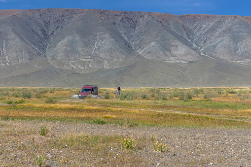 Car and motorbike on road in the desert mountain of the Mongolia