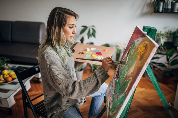 istock One woman painting on a canvas in her home studio 1248903378
