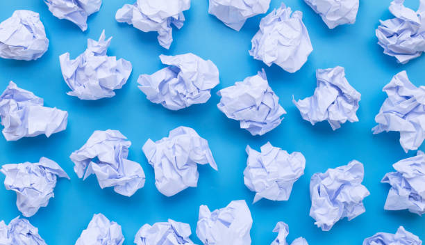 istock White crumpled paper balls on a blue background. 1248906696