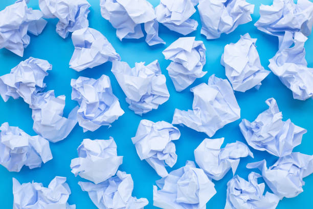 istock White crumpled paper balls on a blue background. 1248907255