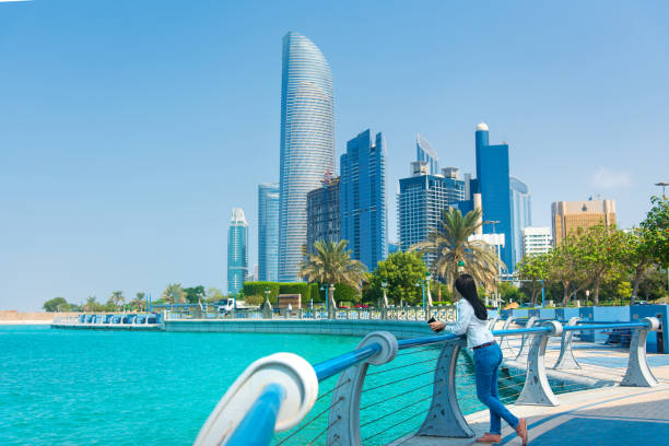 turista femenina visitando la zona de corniche del centro de abu dabi y disfrutando de la vista - cornisa fotografías e imágenes de stock