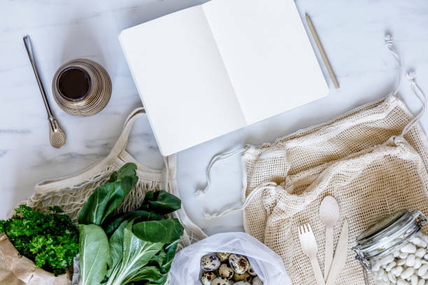 istock Stylish eco composition on the marble table with mock up notebook, zero waste neutral bags, seeds, eggs, herbs, bio vegetables and fresh fruits. Taking care of earth. Stop plastic. 1248916052
