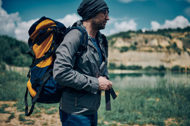 istock Young handsome man standing in nature with backpack on backs. Camping at weekend concept. 1248922434