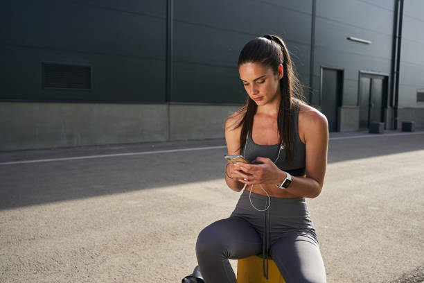 istock Joyful female athlete surfing the net on mobile phone after a long run 1248929295