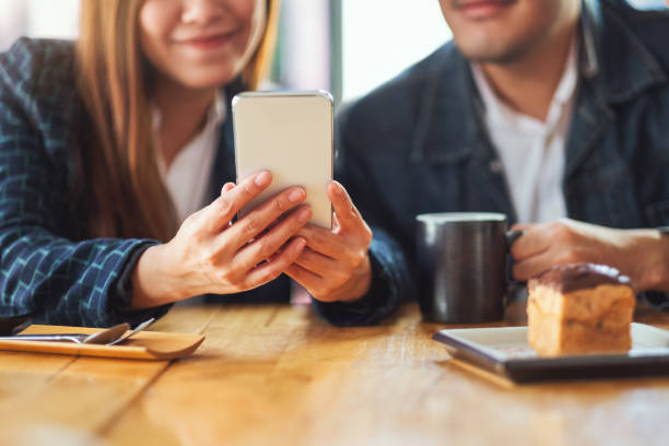 istock A group of young asian people using and looking at the same mobile phone together 1248932516