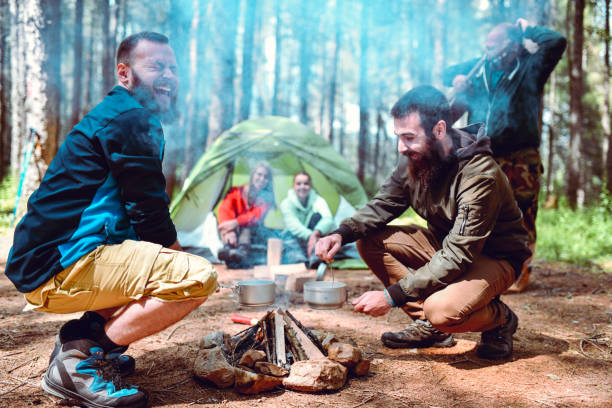 istock Male Closing Eyes From Camp Fire Smoke While Campers Prepare To Make Stew 1248932796