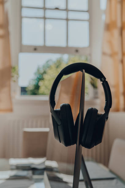 Black headphones resting on a monitor, selective focus.