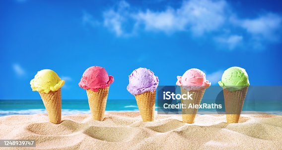 istock Ice creams cones and seashells in the sand on the beach 1248939747