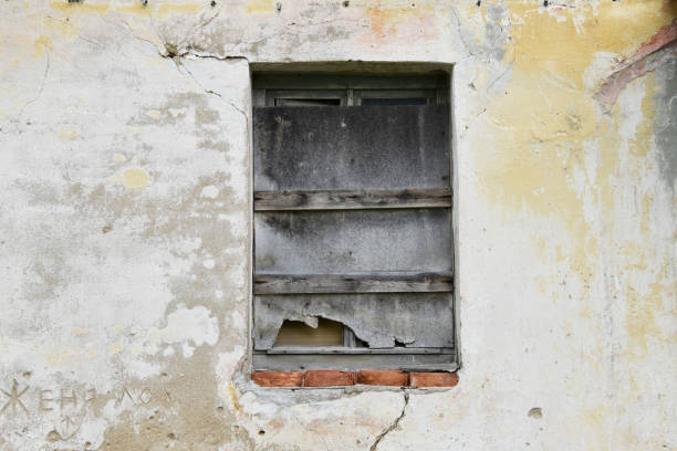 istock Boarded building window with burnt discolored planks. 1248939809