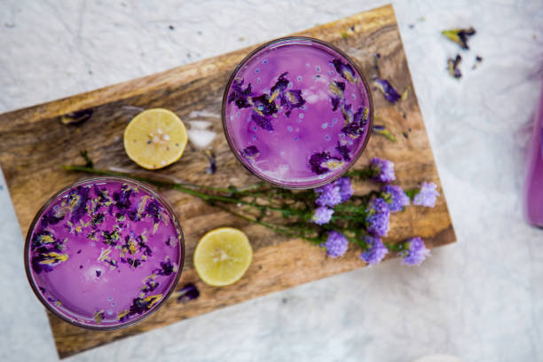 bebida de lavanda fresca com limão e flores de lavanda. limonada violeta de verão frio, vista superior em uma tábua de madeira. - flower drink - fotografias e filmes do acervo