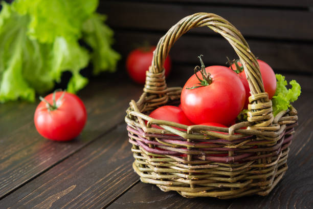 istock Ripe pink tomatoes in a wicker basket 1248946971