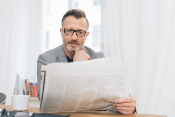 istock Middle-aged man immersed in reading the newspaper 1248946979
