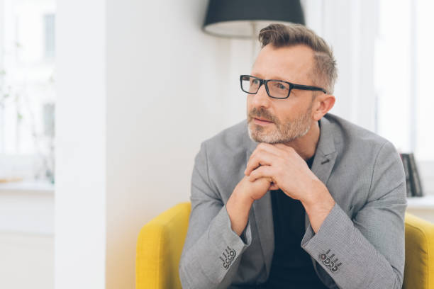 Mature metro man gazing with hands under chin