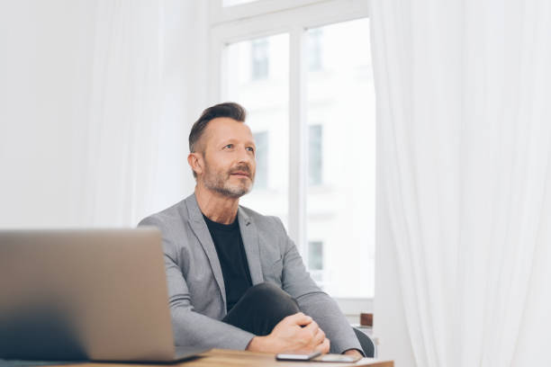 istock Thoughtful mature man sitting at office 1248947304