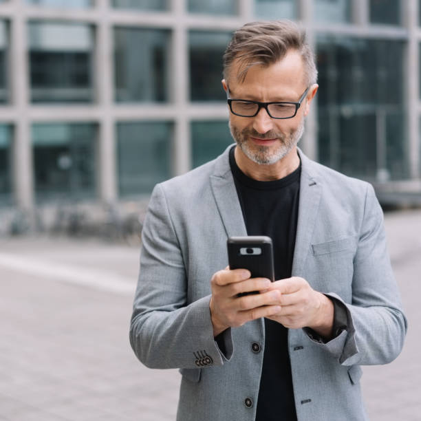 istock Mature metro man texting on phone in urban scene 1248947359