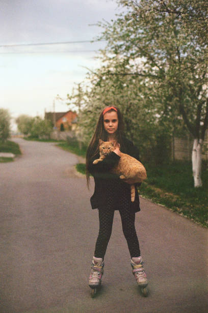 Girl roller skating with cat on hands