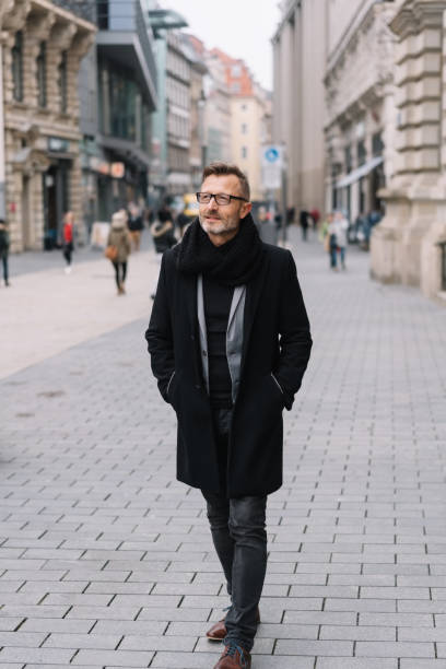 istock Mature man wearing black coat in street 1248950414