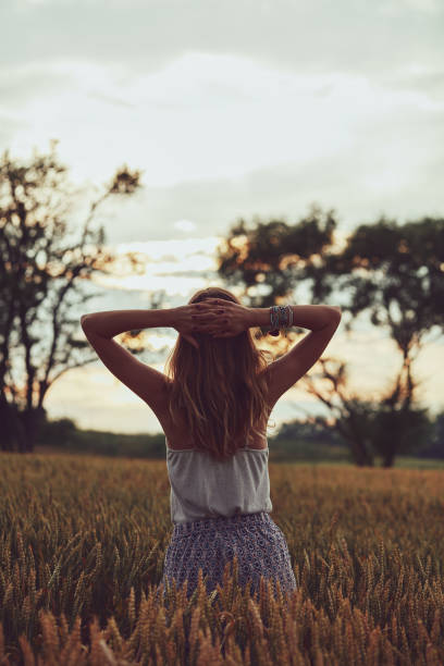 istock Young woman enjoying in a wheat field. 1248950423