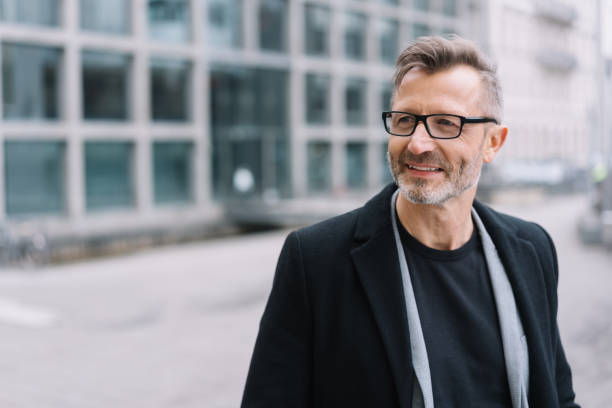 istock Mature smiling man with glasses wearing black coat 1248950432