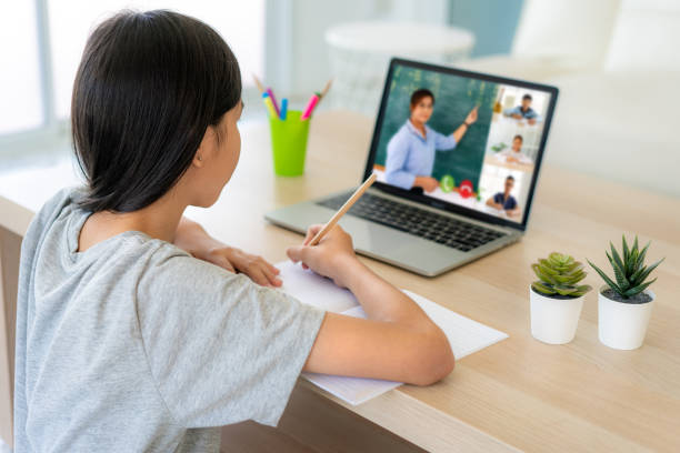 istock Asian girl student video conference e-learning with teacher and classmates on computer in living room at home. Homeschooling and distance learning ,online ,education and internet. 1248950588