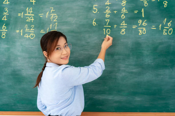istock Asian primary teacher tutor explaining math in blackboard giving remote school class online lesson teaching looking at camera in classroom by e-learning livestream  video conference. 1248950591