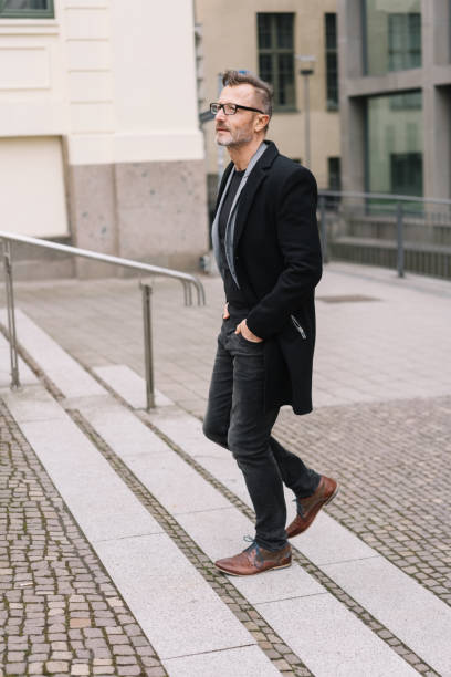 istock Stylish middle-aged man walking through the city 1248950633
