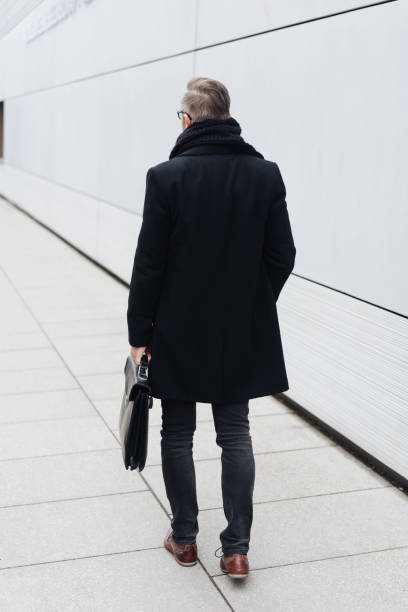 istock Rear view of man walking with briefcase 1248951565