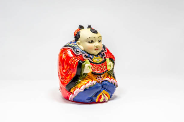 istock Chinese-style pottery doll appealing for savings isolated on white background. 1248951591