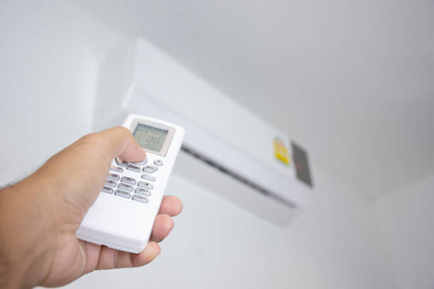 istock Human hand is using white remote of air conditioner 1248953762
